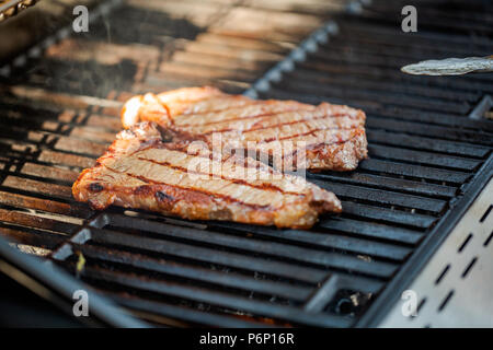 Étape par étape. Cuisson au New York strip steak sur grill au gaz. Banque D'Images