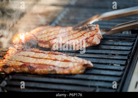 Étape par étape. Cuisson au New York strip steak sur grill au gaz. Banque D'Images