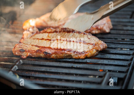 Étape par étape. Cuisson au New York strip steak sur grill au gaz. Banque D'Images