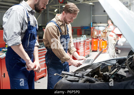 Deux mécaniciens Inspecting Car Banque D'Images