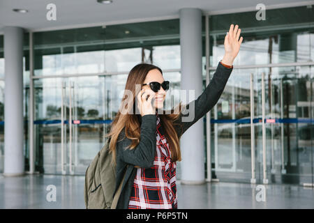 Belle jeune fille touristiques à l'aéroport ou à proximité du centre commercial ou la poste, un taxi ou en parlant sur un téléphone cellulaire ou de communiquer avec des amis en utilisant un téléphone mobile Banque D'Images