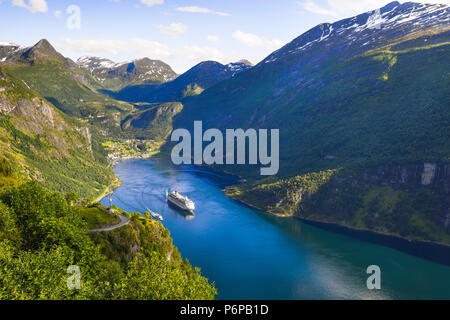 Bateau de croisière quitte baie du fjord de Geiranger, Norvège, dans la lumière du soir, vue panoramique à partir d'Eagle View à l'Ornevegen road Banque D'Images