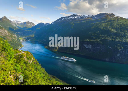 Bateau de croisière quitte baie du fjord de Geiranger, Norvège, dans la lumière du soir, vue panoramique à partir d'Eagle View à l'Ornevegen road Banque D'Images