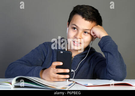 12 ans, écolier à l'aide d'un téléphone cellulaire. Paris, France. Banque D'Images