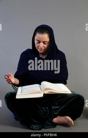 Femme lisant Kuran. Paris, France. Banque D'Images
