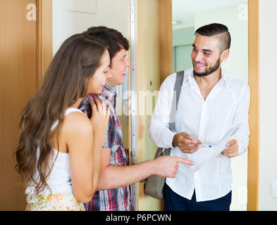 Young salesman retour aux stands et quelques merried in doorway Banque D'Images