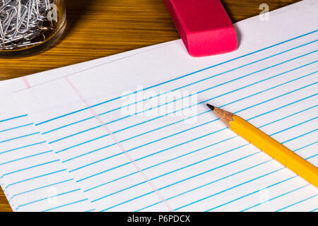 # 2 Un Crayon, gomme, trombones et bouchon de remplissage avec de l'espace papier pour copie. Plusieurs feuilles de papier sont featherd de remplissage ci-dessous. Banque D'Images