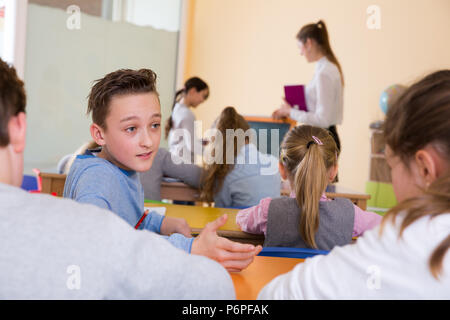 Portrait des enfants discuter quelque chose pendant la leçon à l'école Banque D'Images