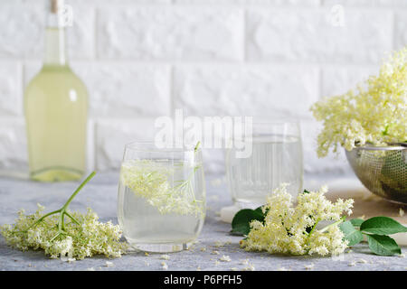 Un verre de limonade de sureau fait maison avec elderflowers fraîchement cueillis. Les fleurs sont comestibles et peuvent être utilisés pour ajouter de la saveur et l'arôme à la fois dri Banque D'Images