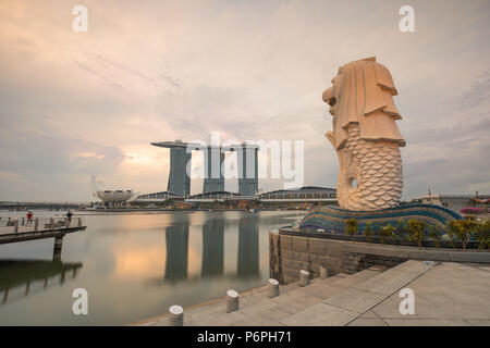 Singapour - Jun 24, 2018 : l'eau Merlion fontaine en face de la skyline de Singapour au cours tôt le matin. Banque D'Images