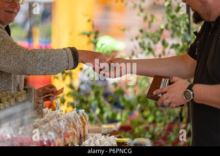 RIGA, Lettonie - 22 juin 2018 : marché du solstice d'été. L'acheteur paie le vendeur des marchandises. Banque D'Images