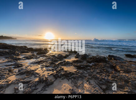 Close up de vagues s'abattant sur les récifs au coucher du soleil sur le Sunset Beach sur la côte nord d'Oahu, Hawaii Banque D'Images