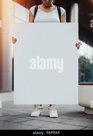 Close up of young woman holding blank canvas sur la rue. Banque D'Images