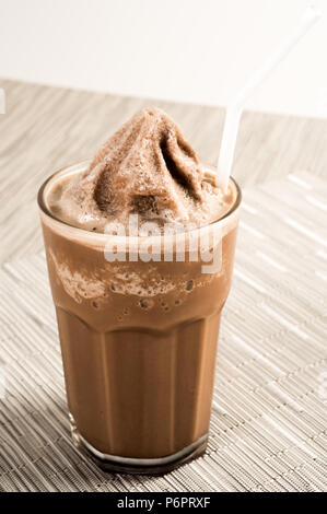 Café avec de la glace dans un grand verre servi avec un sorbet sur un fond de bois Banque D'Images