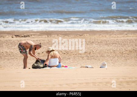 Skegness, Royaume-Uni, 2 juillet 2018. Un jeune couple assis sur la plage profitant du temps chaud actuel au cours d'une canicule, les températures continuent de monter à 30 degrés à travers le Royaume-Uni. Crédit : Steven Booth/Alamy Live News. Banque D'Images