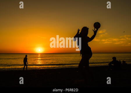 Aberystwyth, UK. 07 juillet, 2018. UK UK Weather : un glorieux coucher de silhouettes jeunes qui jouent sur la plage d'Aberystwyth, à la fin d'une autre scorchingly chaud et serein, comme le jour de canicule prolongée continue à dominer la météo au Royaume-Uni. Crédit photo : Keith morris/Alamy Live News Banque D'Images