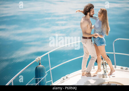 Les amateurs passionnés de danse de race blanche sur l'avant du pont tandis que la voile sur bateau. Jeune couple voyageant ensemble sur le bateau sur la mer, vue magnifique sur la mer avec co Banque D'Images