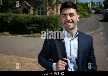 Handsome businessman aux yeux bleus et à l'uniforme dans la rue croix ville rurale Banque D'Images