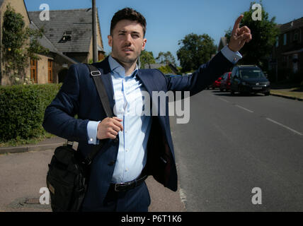 Handsome businessman aux yeux bleus et à l'uniforme dans la rue croix ville rurale Banque D'Images