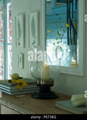 Close-up de cierge allumé en tempête sur la tablette en verre lanterne miroir encadré blanc ci-dessous Banque D'Images