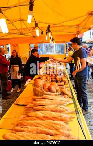 Vue le long marché français avec blocage du pain français, pains et baguettes baguettes sur. Baguettes de premier plan, d'arrière-plan support de calage distribution changement homme. Banque D'Images