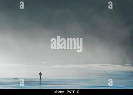 Homme marchant dans la mer le matin, le brouillard de pulvérisation sur Shi Shi Beach le long de l'océan Pacifique à l'Olympic National Park, Washington State, USA Banque D'Images