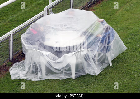 Hambourg, spectateurs assis dans la pluie sous une bâche de plastique à une table sur la course Banque D'Images