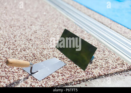 Béton coloré autour de la piscine avec des outils Banque D'Images