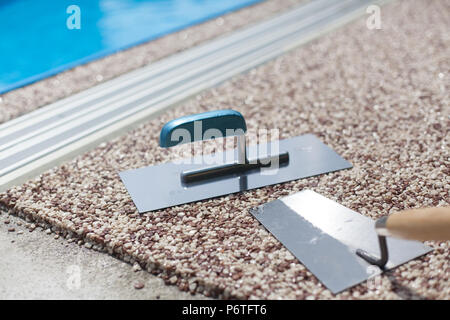 Béton coloré autour de la piscine avec des outils Banque D'Images