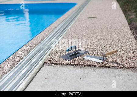 Béton coloré autour de la piscine avec des outils Banque D'Images