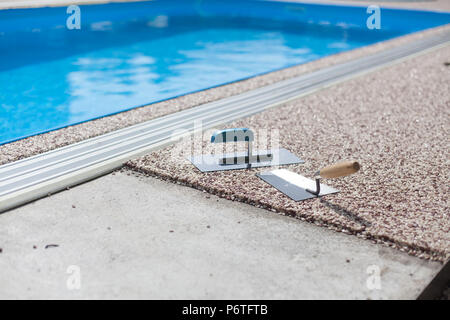 Béton coloré autour de la piscine avec des outils Banque D'Images