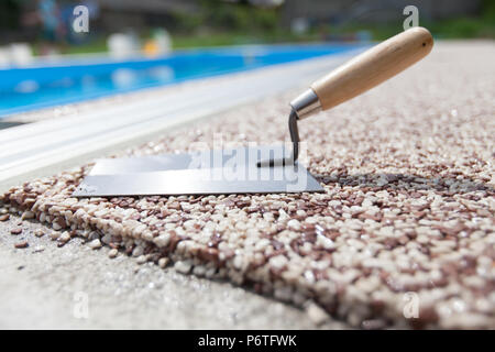 Béton coloré autour de la piscine avec des outils Banque D'Images