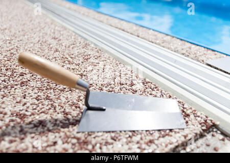 Béton coloré autour de la piscine avec des outils Banque D'Images