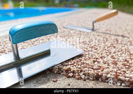 Béton coloré autour de la piscine avec des outils Banque D'Images