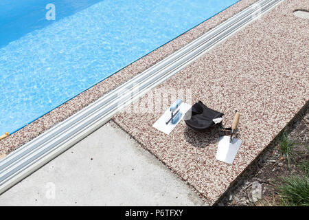 Béton coloré autour de la piscine avec des outils Banque D'Images