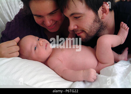 Happy smiling parents regardant adoringly leur bébé Banque D'Images