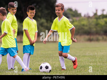 Les jeunes enfants joueurs match sur terrain de football Banque D'Images