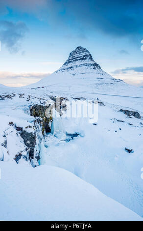 La péninsule de Snaefellsness, dans l'ouest de l'Islande, l'Europe. Chute d'Kirkjufellfoss congelés en hiver avec Kirkjufell mountain dans la toile. Banque D'Images