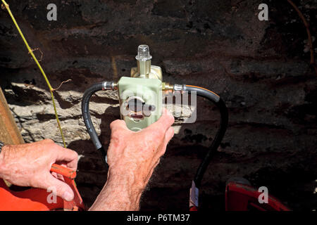 Mécanicien d'un montage d'une vanne d'inversion 2 pack avec plus d'arrêt de pression de bouteilles de gaz GPL carburant qu'une cuisinière à gaz dans les régions rurales du pays de Galles UK KATHY DEWITT Banque D'Images