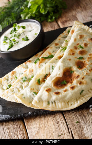 L'alimentation de l'Azerbaïdjan : galette qutab avec les verts et le yogourt close-up sur la table. La verticale Banque D'Images