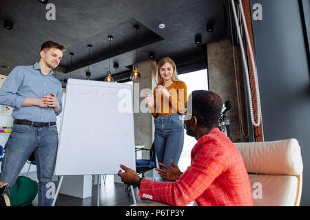 Deux jeunes businesswoman préparer une présentation debout ensemble en face d'un tableau de conférence avec un graphique sur elle Banque D'Images