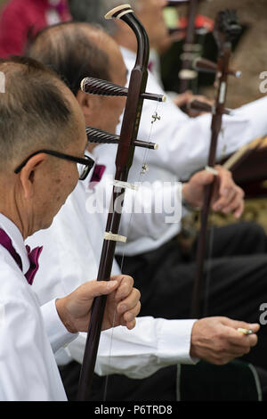 L'homme jouant un instrument de musique chinois appelé erhu à la célébration de la fête du Canada dans le quartier chinois de Calgary Banque D'Images