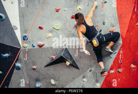 Succès sportif business woman étant occupé à son passe-temps-bloc. Femme bien équipée de la formation dans une salle d'escalade de couleur, la préparation à l'été, moun Banque D'Images