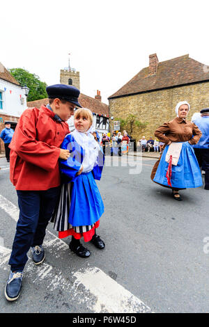 Les enfants, garçon, en costume de marin, et fille, en matelote costume, 8-9 ans, du groupe de danse française, Les Soleils Boulonnais, en dansant dans la rue. Banque D'Images