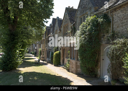 Rangée de maisons anciennes en pierre face à un point d'herbe dans la rue mouton côté de la rue High Street à Burford, marché de la ville historique dans les Cotswolds, Royaume-Uni Banque D'Images