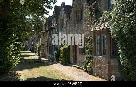 Rangée de maisons anciennes en pierre face à un point d'herbe dans la rue mouton côté de la rue High Street à Burford, marché de la ville historique dans les Cotswolds, Royaume-Uni Banque D'Images