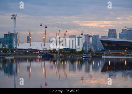 Vue de la ville de Londres, Canary Wharf, la ligne d'Horizon Air sky tram, et de l'O2 Arena se reflétant dans l'eau du Royal Victoria Dock au coucher du soleil Banque D'Images