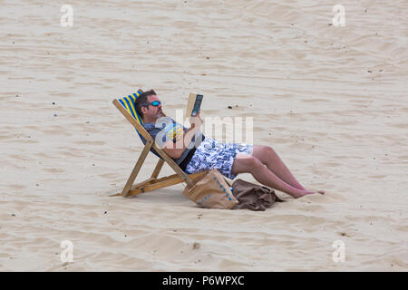 Bournemouth, Dorset, UK. 3e juillet 2018. Météo France : hazy sunshine, mais encore chaud et avec une agréable brise fraîche comme sunseekers chef à la mer. Credit : Carolyn Jenkins/Alamy Live News Banque D'Images