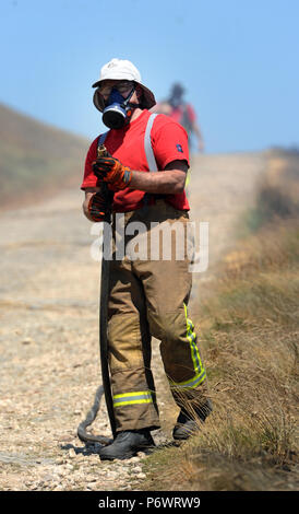 Bolton, Lancashire, UK. 2 juillet, 2018. Les pompiers de Lancashire et autres forces continuent de s'attaquer à un énorme incendie landes sur la colline d'hiver près de Bolton, Lancashire. Le brasier a été commencé et délibérément fait rage pendant six jours couvrant une superficie de 7 kilomètres carrés. Les pompiers de la Lancaster inscrivez-vous dans l'effort à l'aide de tiges de pénétration du sol pour combattre le feu au-dessous du sol. Banque D'Images