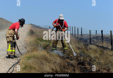 Bolton, Lancashire, UK. 2 juillet, 2018. Les pompiers de Lancashire et autres forces continuent de s'attaquer à un énorme incendie landes sur la colline d'hiver près de Bolton, Lancashire. Le brasier a été commencé et délibérément fait rage pendant six jours couvrant une superficie de 7 kilomètres carrés. Les pompiers de la Lancaster inscrivez-vous dans l'effort à l'aide de tiges de pénétration du sol pour combattre le feu au-dessous du sol. Banque D'Images